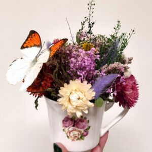 Porseleinen theekopje versierd met echte vlinder en droogbloemen